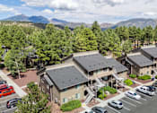Thumbnail 5 of 18 - A parking lot with cars and a building in the background.