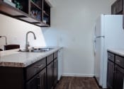 Thumbnail 15 of 26 - a kitchen with dark cabinets and a white refrigerator