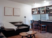 Thumbnail 17 of 26 - a living room with a couch a table and a kitchen in the background