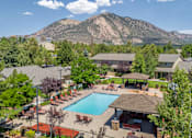 Thumbnail 13 of 34 - A large swimming pool surrounded by a patio and a mountain in the background.