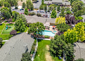 Thumbnail 4 of 32 - A bird's eye view of a residential area with houses, trees, and a pool.