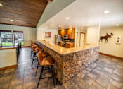 Thumbnail 15 of 32 - A bar area with a stone counter and chairs.