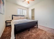 Thumbnail 29 of 32 - A bedroom with a bed, carpet, and a ceiling fan.