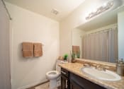 Thumbnail 28 of 32 - A bathroom with a toilet, sink, and towels.