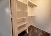 Thumbnail 22 of 32 - A white closet with shelves and hangers.