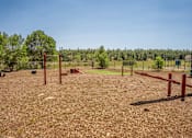 Thumbnail 12 of 21 - A dog park with red posts and a fence.