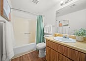 Thumbnail 8 of 20 - A bathroom with a toilet, sink, and shower.