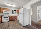 Thumbnail 10 of 20 - A kitchen with wooden cabinets and a white refrigerator.