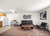 Thumbnail 7 of 20 - A living room with a black leather couch and a wooden coffee table.