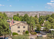 Thumbnail 1 of 16 - A building with the sign "Mountain View Apartments" is surrounded by trees and has an American flag flying in front of it.