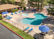Thumbnail 4 of 16 - A pool surrounded by chairs and umbrellas.
