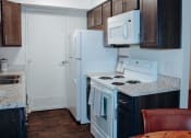 Thumbnail 13 of 26 - a kitchen with a white refrigerator freezer next to a stove top oven