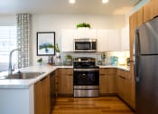 Thumbnail 24 of 32 - a kitchen with white cabinets and stainless steel appliances