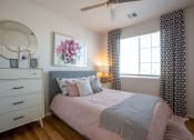 Thumbnail 21 of 32 - a bedroom with a bed and a dresser with a mirror on top of it