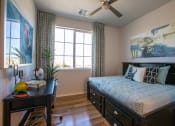 Thumbnail 13 of 32 - a bedroom with a large window and a desk with a plant