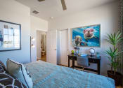 Thumbnail 14 of 32 - a bedroom with a large bed and a desk with a chair