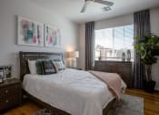 Thumbnail 15 of 32 - a bedroom with a large window and a ceiling fan
