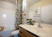 Thumbnail 26 of 32 - a bathroom with a white sink and toilet next to a tub with a shower curtain
