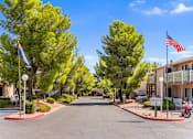 Thumbnail 22 of 22 - A street view of a residential area with houses on both sides and trees lining the road.
