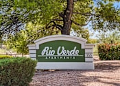 Thumbnail 1 of 22 - A sign for Rio Verde Apartments is displayed in front of a tree.