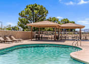 Thumbnail 4 of 22 - A pool with a sunshade and lounge chairs.
