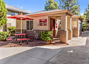 Thumbnail 14 of 16 - A small building with a red umbrella and picnic table in front.