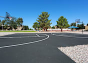 Thumbnail 1 of 22 - a basketball court in a park with trees