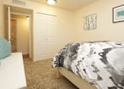 Thumbnail 16 of 22 - a bedroom with a bed and a door to a bathroom