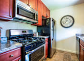 Thumbnail 21 of 22 - a kitchen with stainless steel appliances and a clock