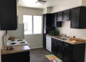 Thumbnail 5 of 38 - a kitchen with black cabinets and white appliances