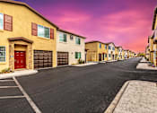 Thumbnail 3 of 32 - A row of houses with garages and driveways.