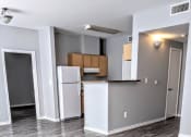 Thumbnail 3 of 17 - an empty room with a kitchen and a refrigerator