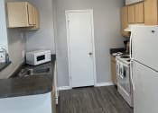 Thumbnail 6 of 17 - an empty kitchen with white appliances and a refrigerator