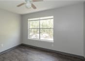 Thumbnail 10 of 10 - an empty bedroom with a large window and wood flooring