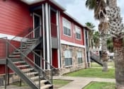 Thumbnail 3 of 10 - a red house with stairs and a palm tree