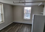 Thumbnail 9 of 9 - an empty room with a refrigerator and two windows