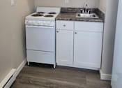 Thumbnail 7 of 9 - a small kitchen with a stove sink and cupboards