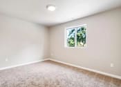 Thumbnail 9 of 48 - A room with a window and carpeted floor.