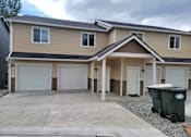 Thumbnail 2 of 48 - A two-story house with a garage and a driveway.