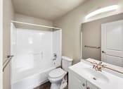 Thumbnail 11 of 17 - A white bathroom with a toilet, sink, and shower.