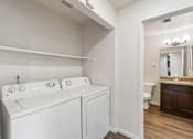 Thumbnail 7 of 26 - a white washer and dryer in a room with a bathroom and a toilet