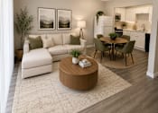 Thumbnail 6 of 11 - A modern living room with a white sofa, a wooden coffee table, and a dining table with chairs.