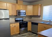 Thumbnail 67 of 82 - A kitchen with wooden cabinets and a black fridge.