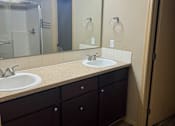 Thumbnail 46 of 82 - A bathroom with a mirror, sink, and lighting fixture.