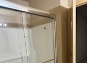 Thumbnail 54 of 82 - A white shower with a glass door and a silver handle.