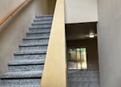 Thumbnail 28 of 82 - A room with a long wooden ledge and a wall with a grey pattern.