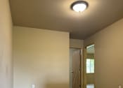 Thumbnail 22 of 82 - A wall with a circular light fixture on the left side and a textured wall on the right side.