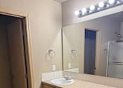 Thumbnail 31 of 82 - A bathroom with a mirror, light, and a toilet.