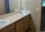 Thumbnail 25 of 82 - A bathroom with a mirror, light, and sink.