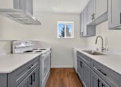 Thumbnail 13 of 42 - A kitchen with a white counter top and grey cabinets.